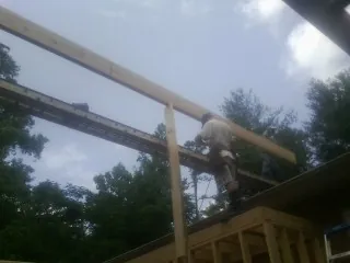 Carpenter setting a ridge beam over a new addition frame — Ice Dam Removal by Roofing Brothers in Prudence Island