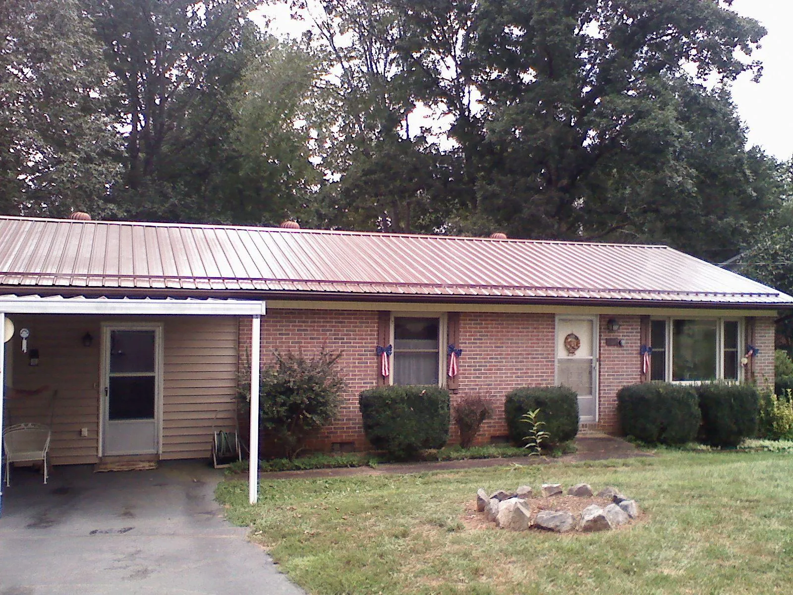 Bronze metal roof and carport on a brick ranch home — Roof Repair work by our crew in Prudence Island